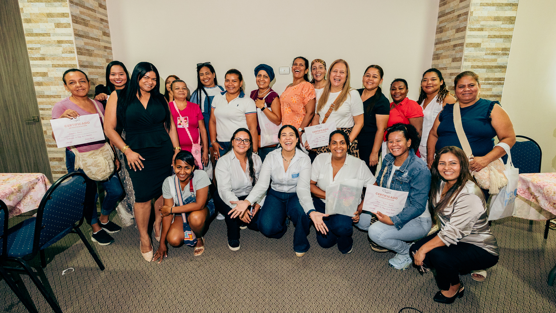 Grupo de mujeres emprendedoras con sus certificados en un encuentro Fintra Mujer